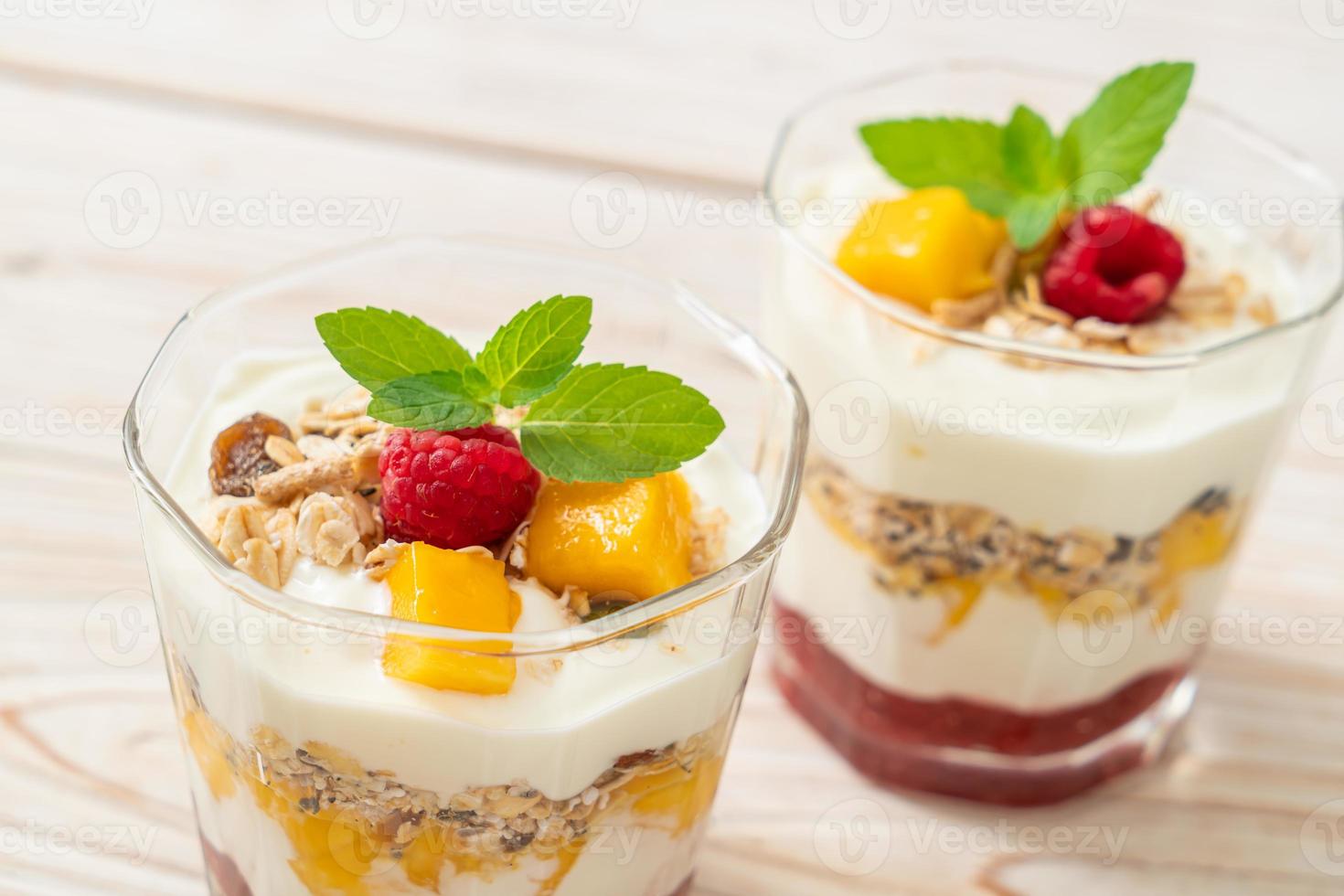 zelfgemaakte verse mango en verse framboos met yoghurt en granola - healthy food style foto