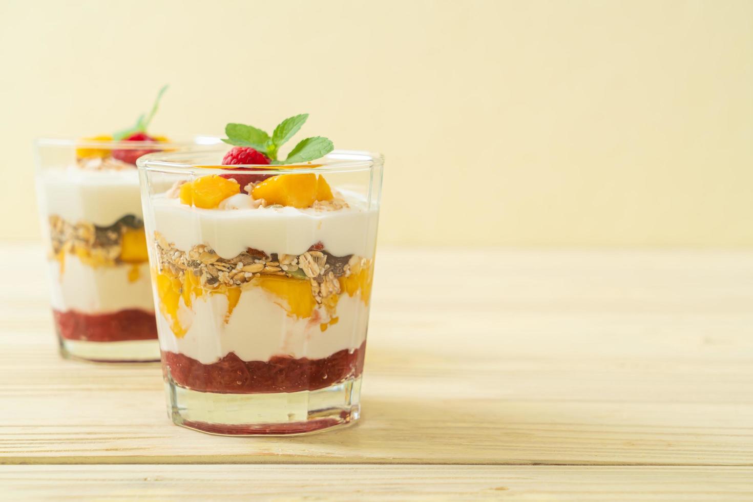 zelfgemaakte verse mango en verse framboos met yoghurt en granola - healthy food style foto