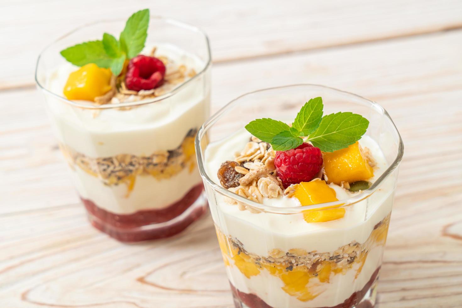 zelfgemaakte verse mango en verse framboos met yoghurt en granola - healthy food style foto