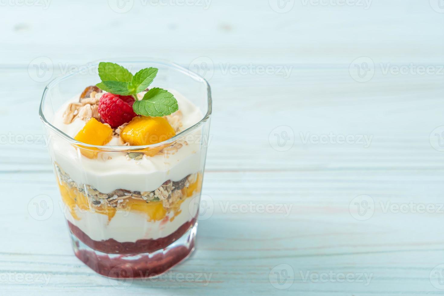 zelfgemaakte verse mango en verse framboos met yoghurt en granola - healthy food style foto