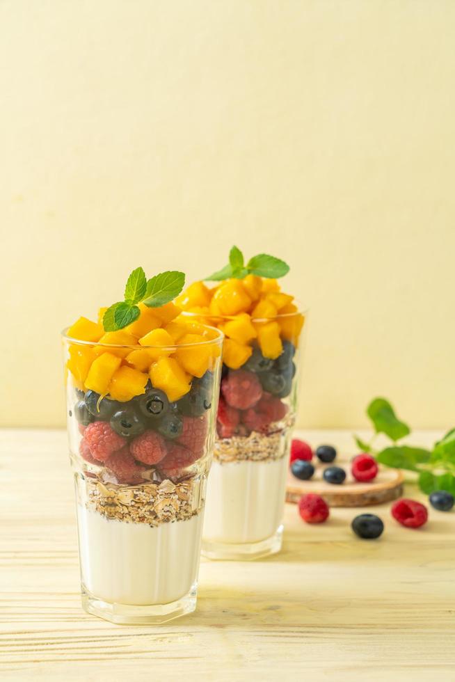 zelfgemaakte verse mango en verse framboos met yoghurt en granola - healthy food style foto