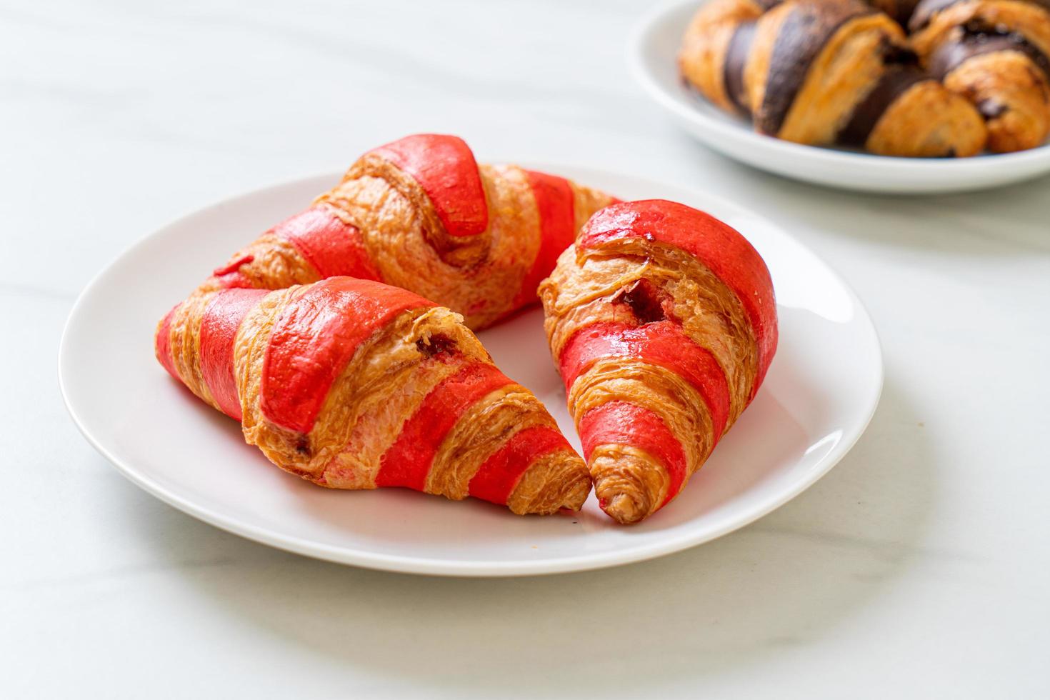 verse croissant met aardbeienjamsaus op bord foto