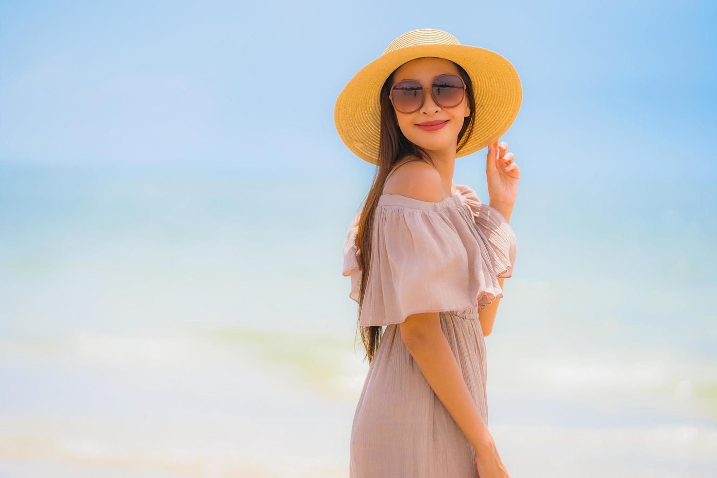 portret mooie jonge aziatische vrouw gelukkige glimlach ontspannen op het tropische strand zee oceaan foto