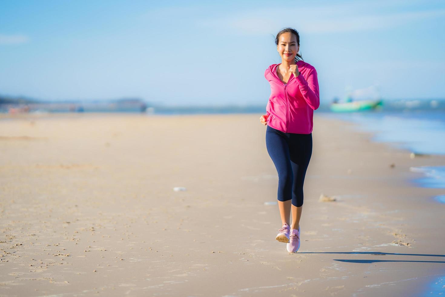portret mooie jonge aziatische vrouw die loopt en oefent op het tropische natuurstrand, zee, oceaan foto