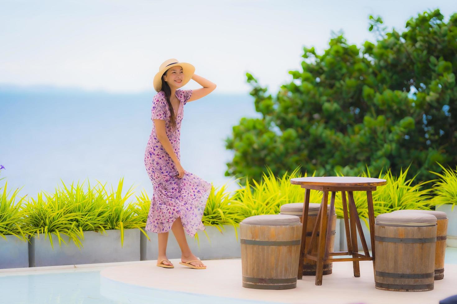 portret mooie jonge aziatische vrouw die naar zee oceaan kijkt met een gelukkige glimlach om te ontspannen vrije tijd in vakantie foto