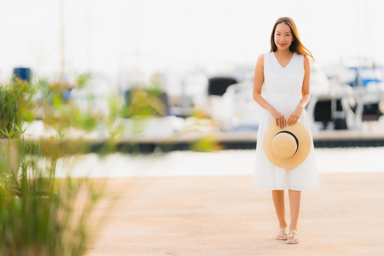 portret mooie jonge aziatische vrouw vrije tijd glimlach gelukkig ontspannen rond jachthaven foto