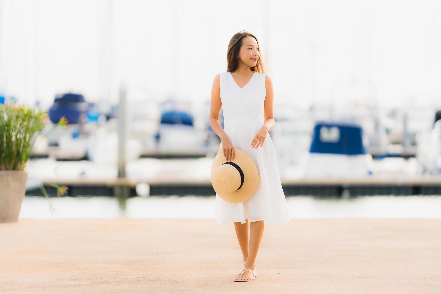 portret mooie jonge aziatische vrouw vrije tijd glimlach gelukkig ontspannen rond jachthaven foto