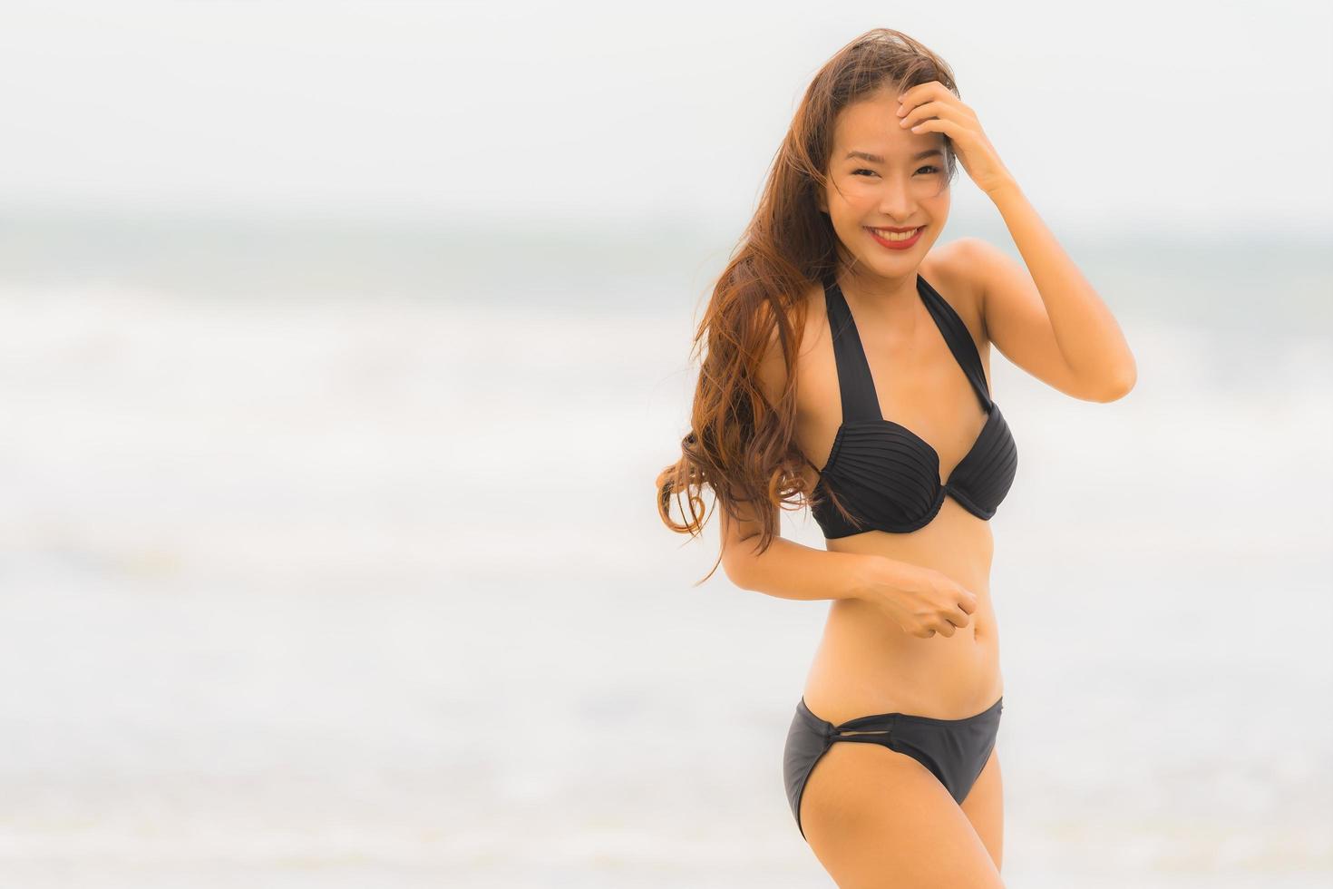portret mooie jonge aziatische vrouw draagt bikini op het strand zee oceaan foto