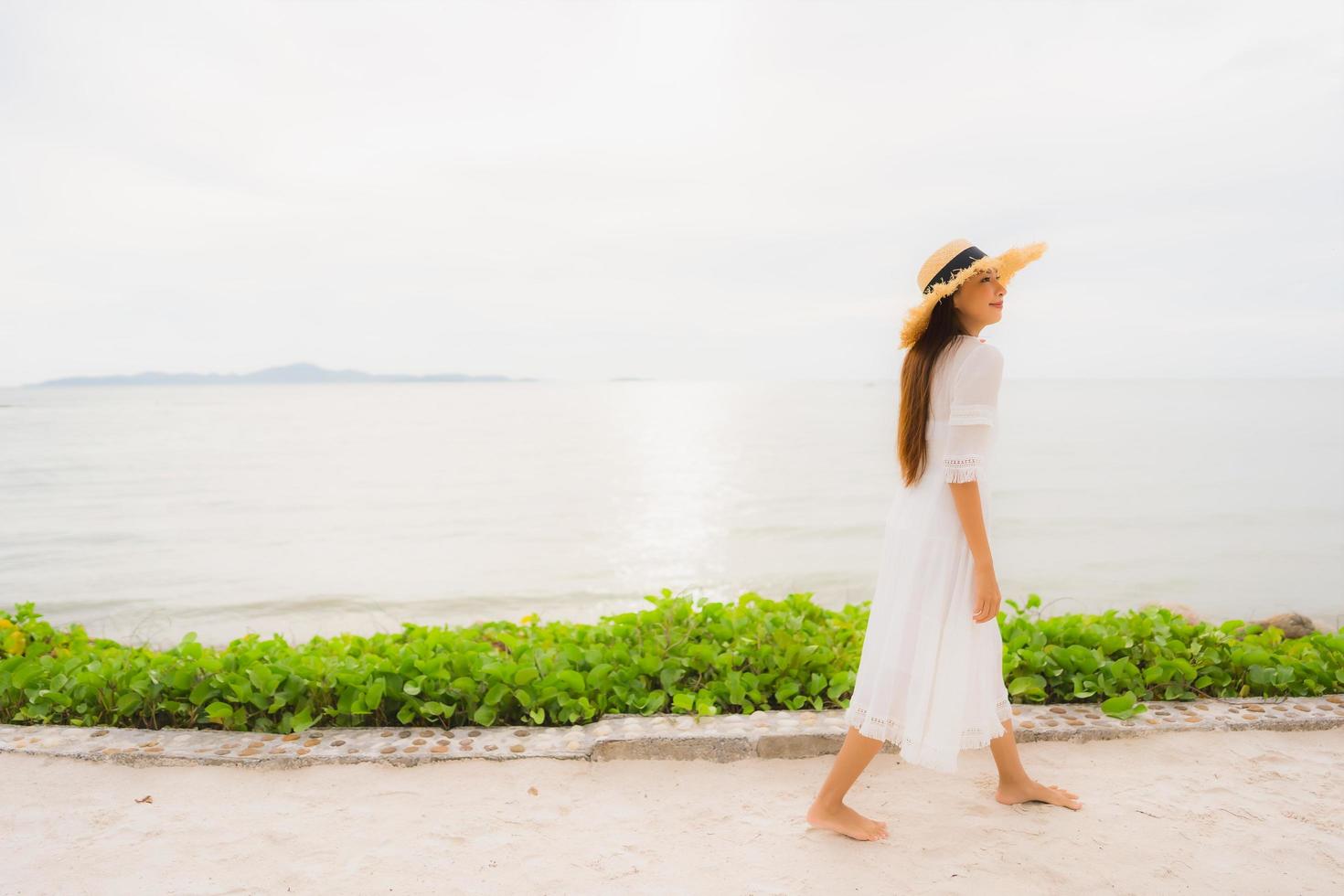 portret mooie aziatische vrouw draagt hoed met glimlach gelukkige vrije tijd op het strand en de zee in vakantievakantie foto