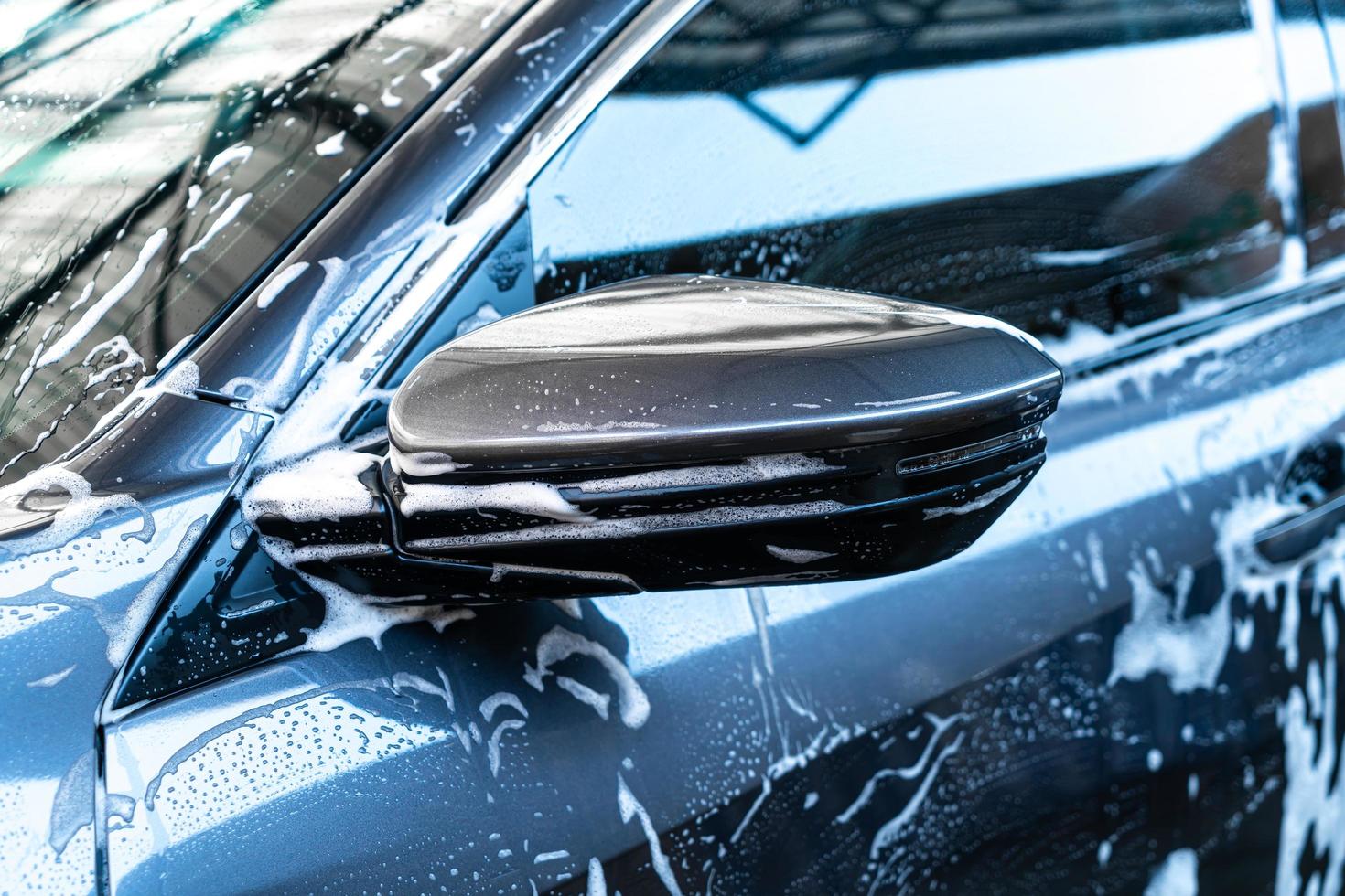 close-up auto zijspiegel met autowasschuim foto