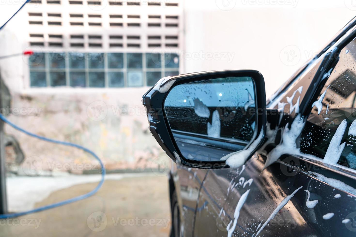 close-up auto zijspiegel met autowasschuim foto