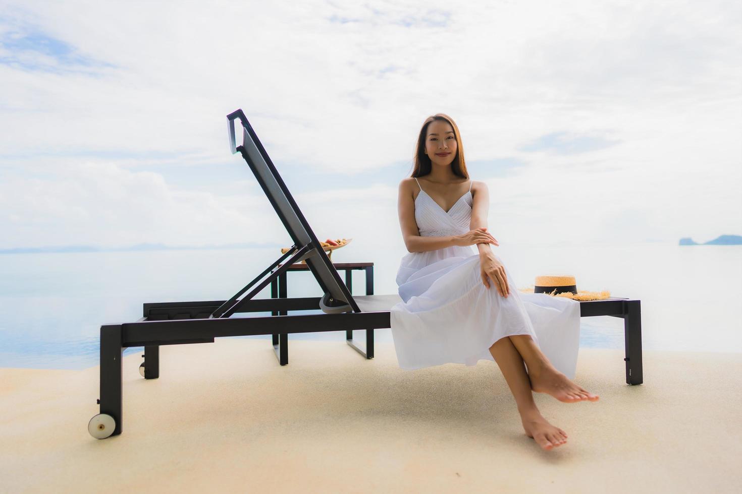 portret jonge aziatische vrouw ontspannen glimlach gelukkig rond het zwembad in hotel en resort foto