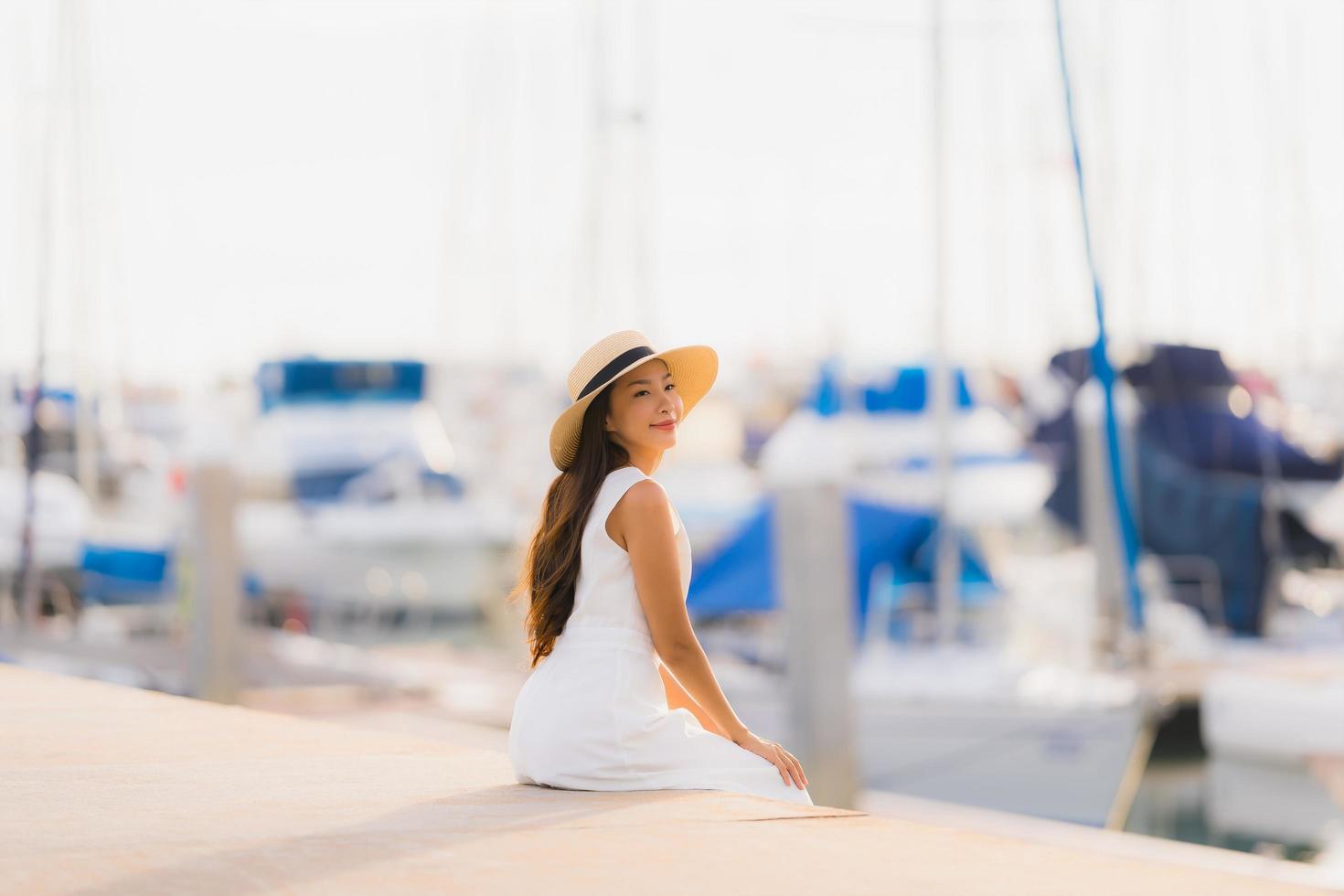 portret mooie jonge aziatische vrouw vrije tijd glimlach gelukkig ontspannen rond jachthaven foto