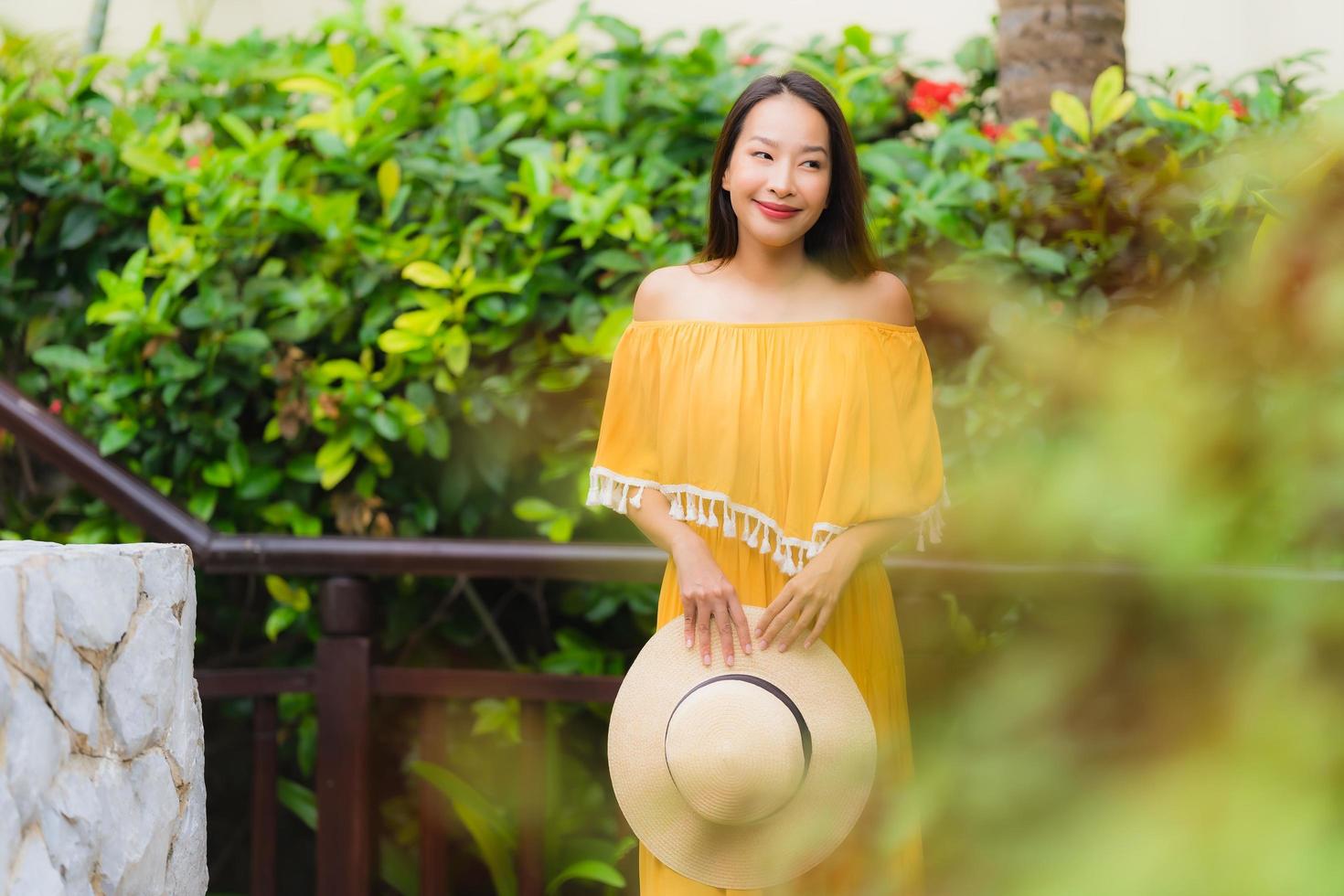 portret mooie jonge aziatische vrouw gelukkige glimlach lesire in het tuinpark foto