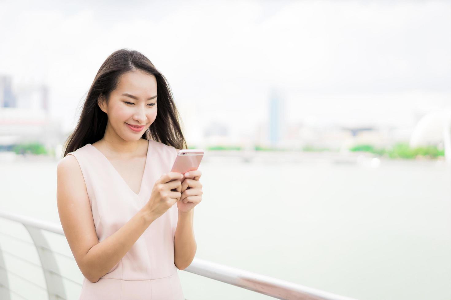 Aziatische vrouw die smartphone of mobiele telefoon gebruikt om te praten of te sms'en foto