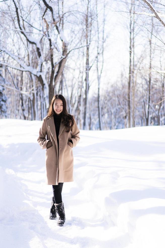 portret jonge mooie aziatische vrouw glimlach gelukkig reizen en genieten met sneeuw winterseizoen foto