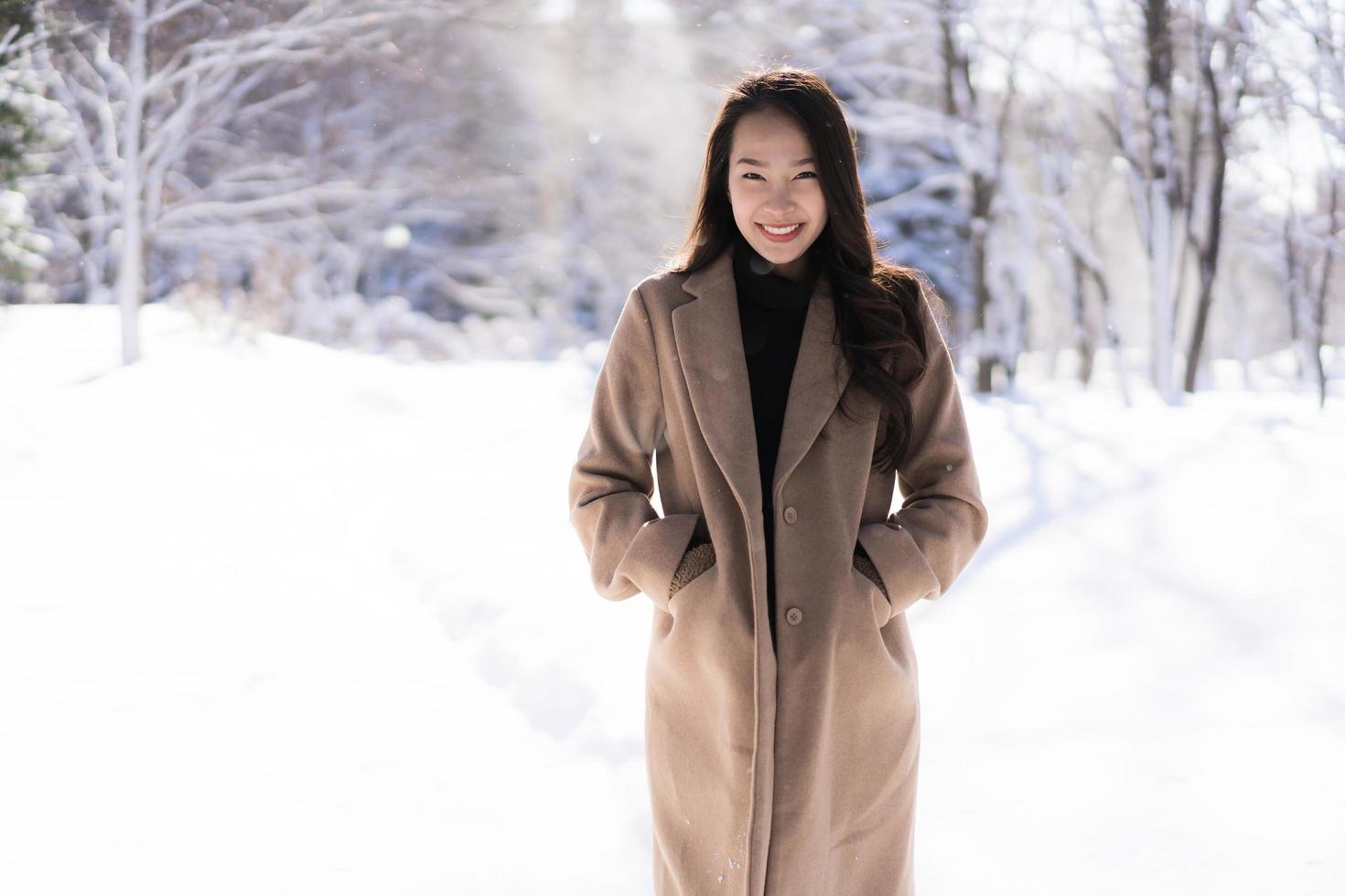 portret jonge mooie aziatische vrouw glimlach gelukkig reizen en genieten met sneeuw winterseizoen foto