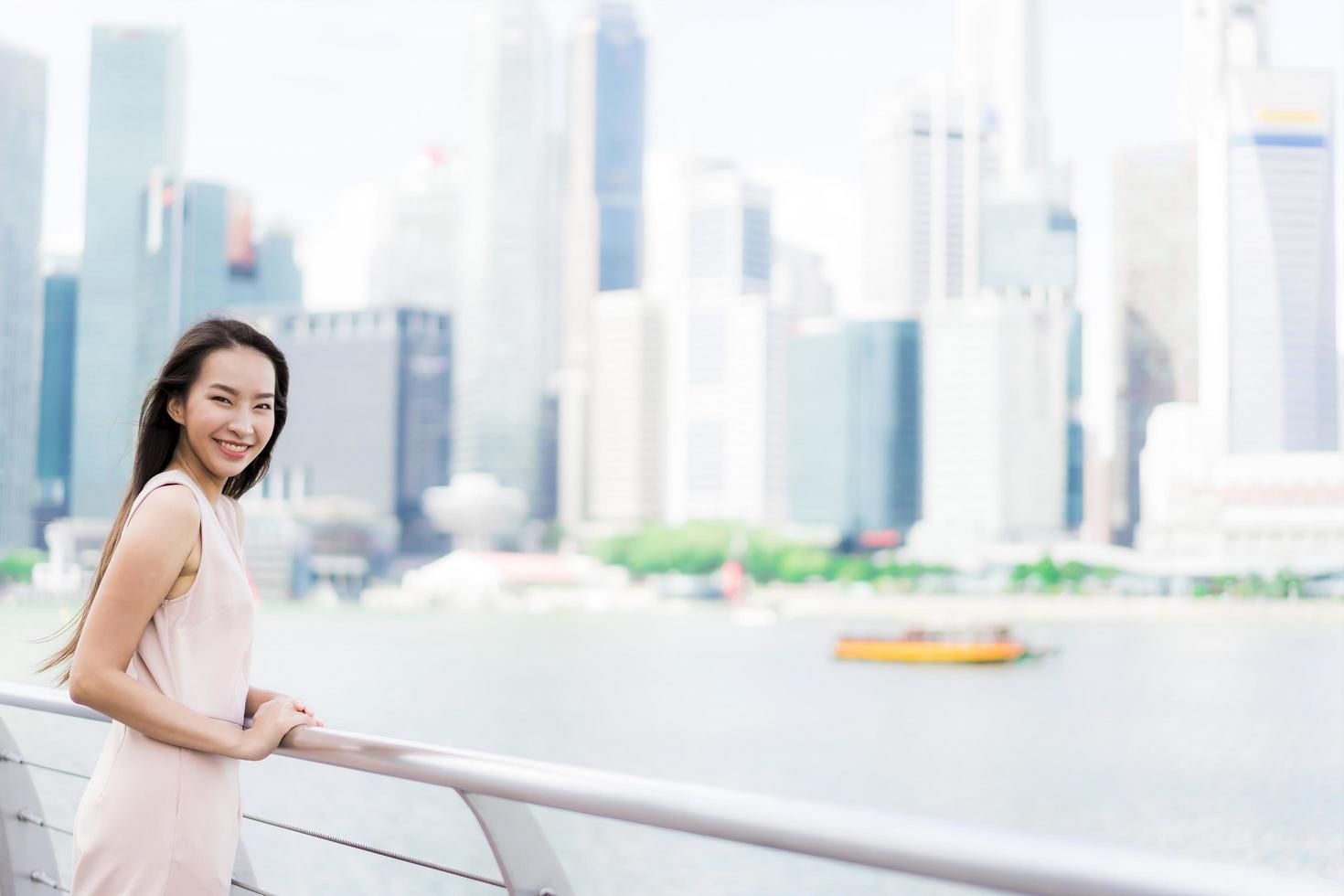 mooie aziatische vrouw glimlach en blij om te reizen in singapore city foto