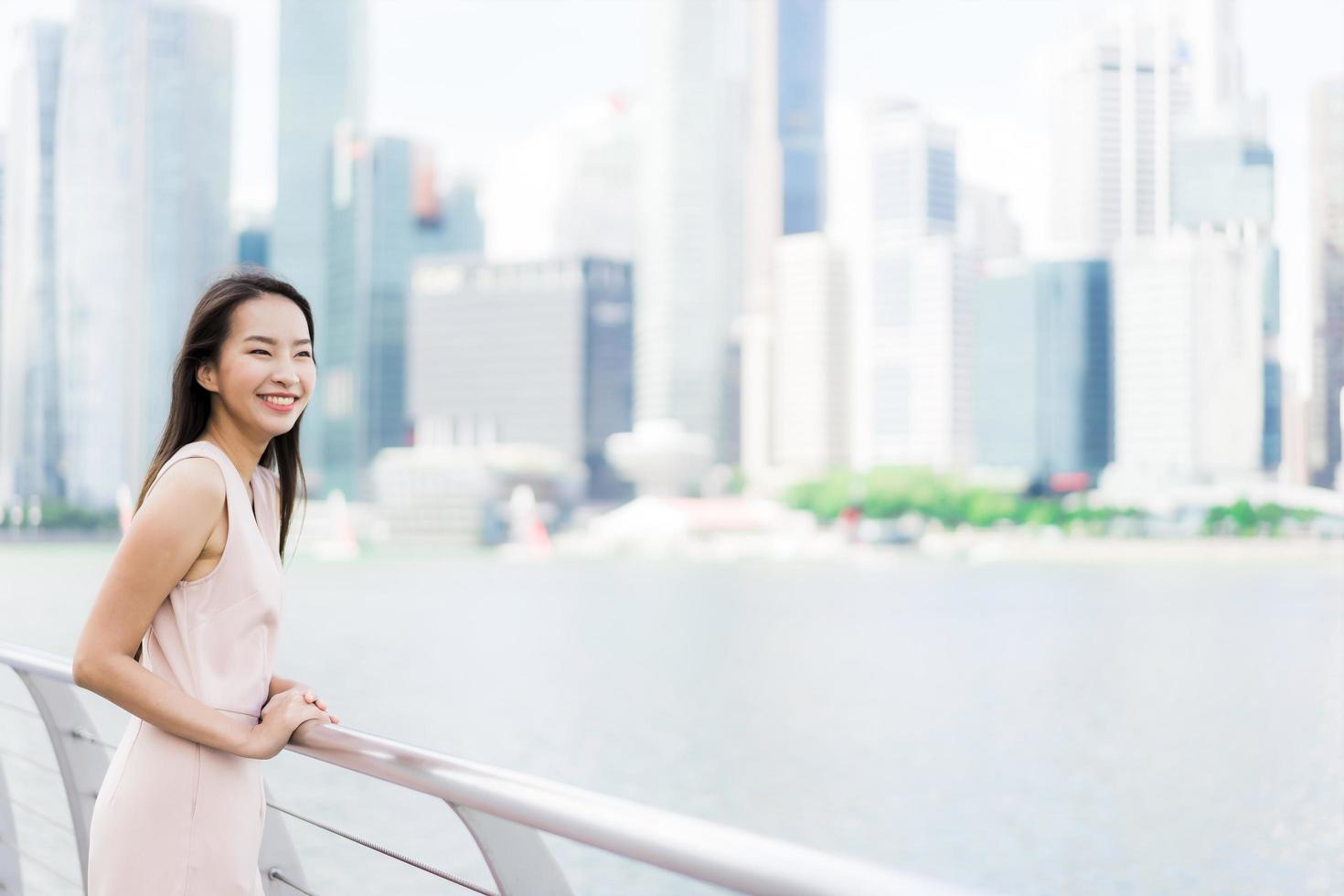 mooie aziatische vrouw glimlach en blij om te reizen in singapore city foto