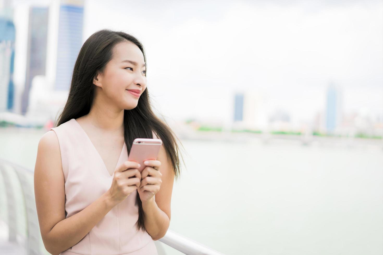 Aziatische vrouw die smartphone of mobiele telefoon gebruikt om te praten of te sms'en foto
