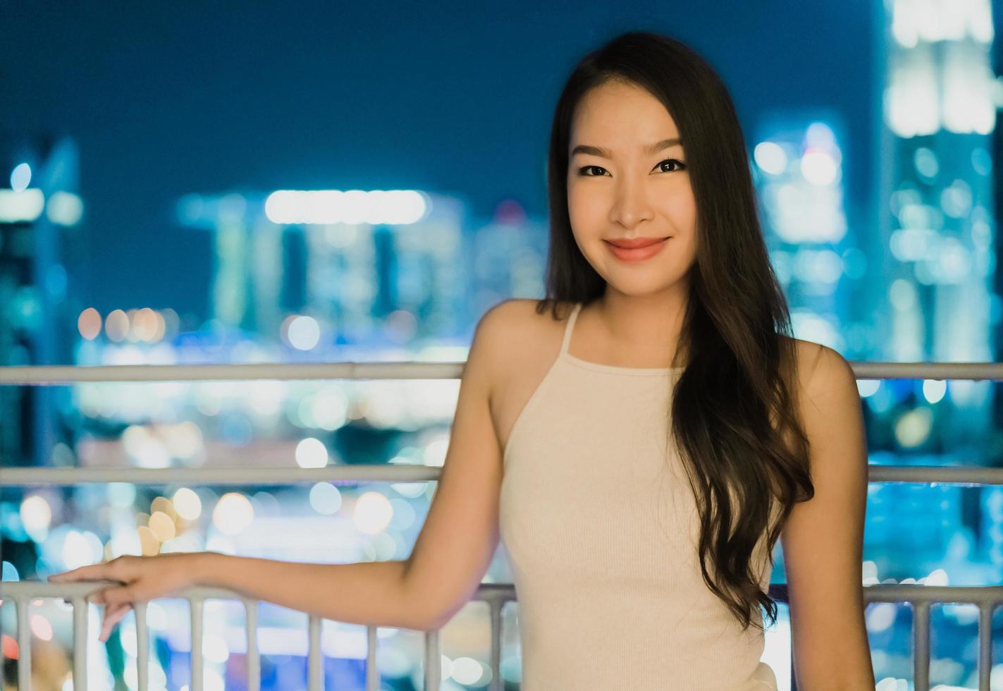 mooie aziatische vrouwen glimlachen en blij met het uitzicht op de stad singapore foto