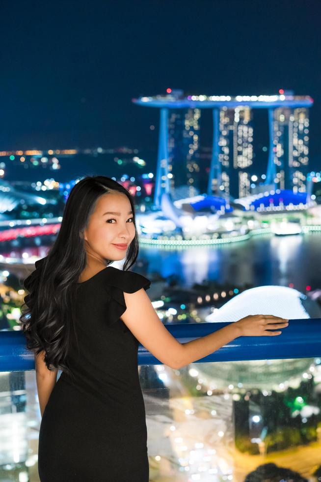 mooie aziatische vrouwen glimlachen en blij met het uitzicht op de stad singapore foto