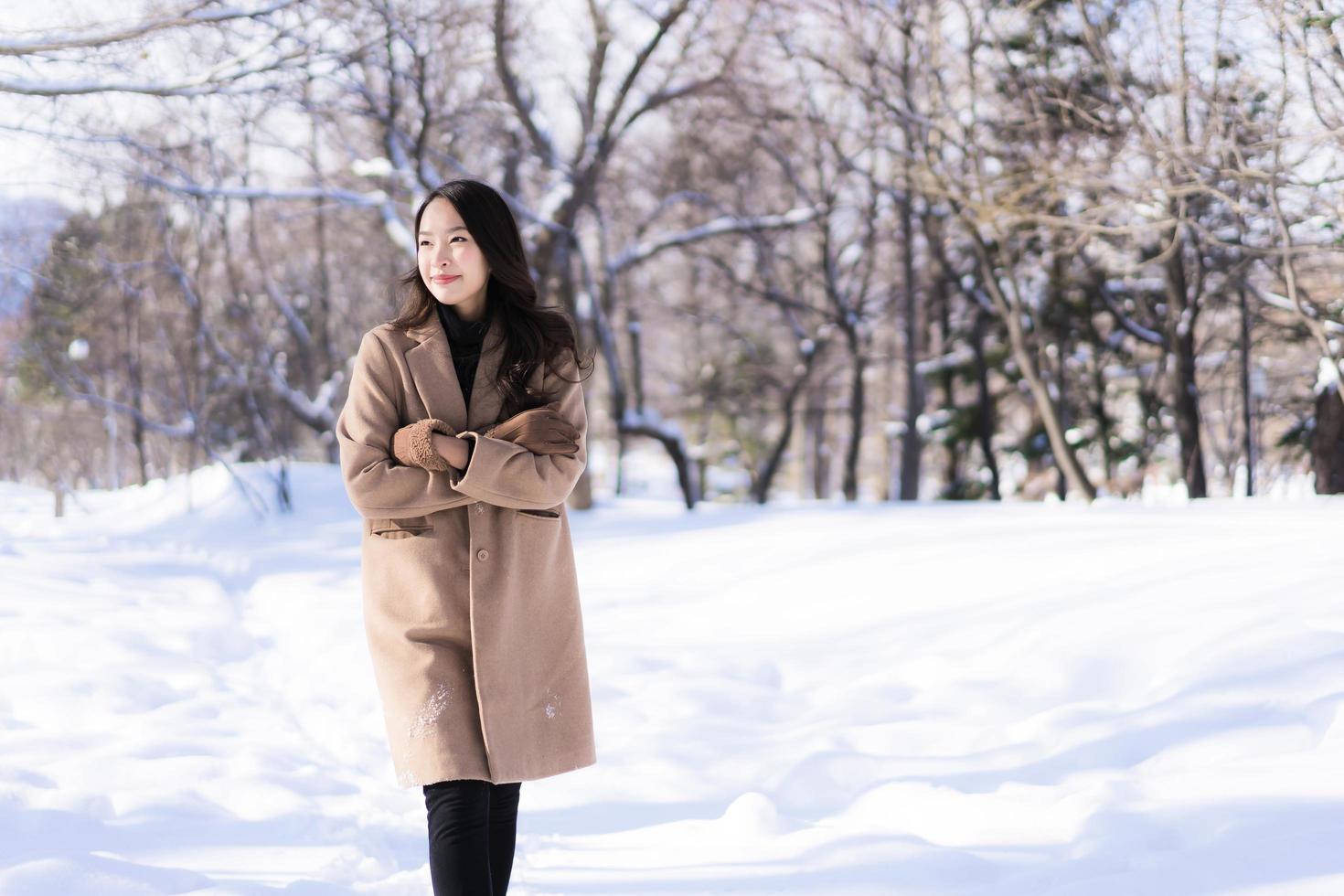 portret jonge mooie aziatische vrouw glimlach gelukkig reizen en genieten met sneeuw winterseizoen foto