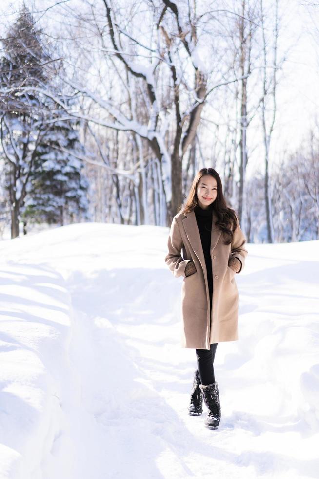 portret jonge mooie aziatische vrouw glimlach gelukkig reizen en genieten met sneeuw winterseizoen foto