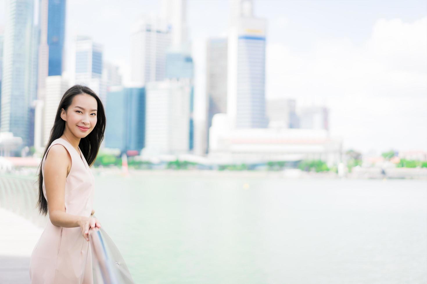 mooie aziatische vrouw glimlach en blij om te reizen in singapore city foto