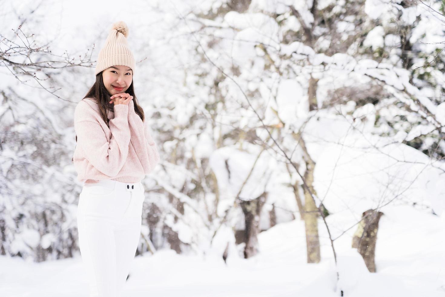 portret jonge mooie aziatische vrouw glimlach gelukkig reizen en genieten met sneeuw winterseizoen foto