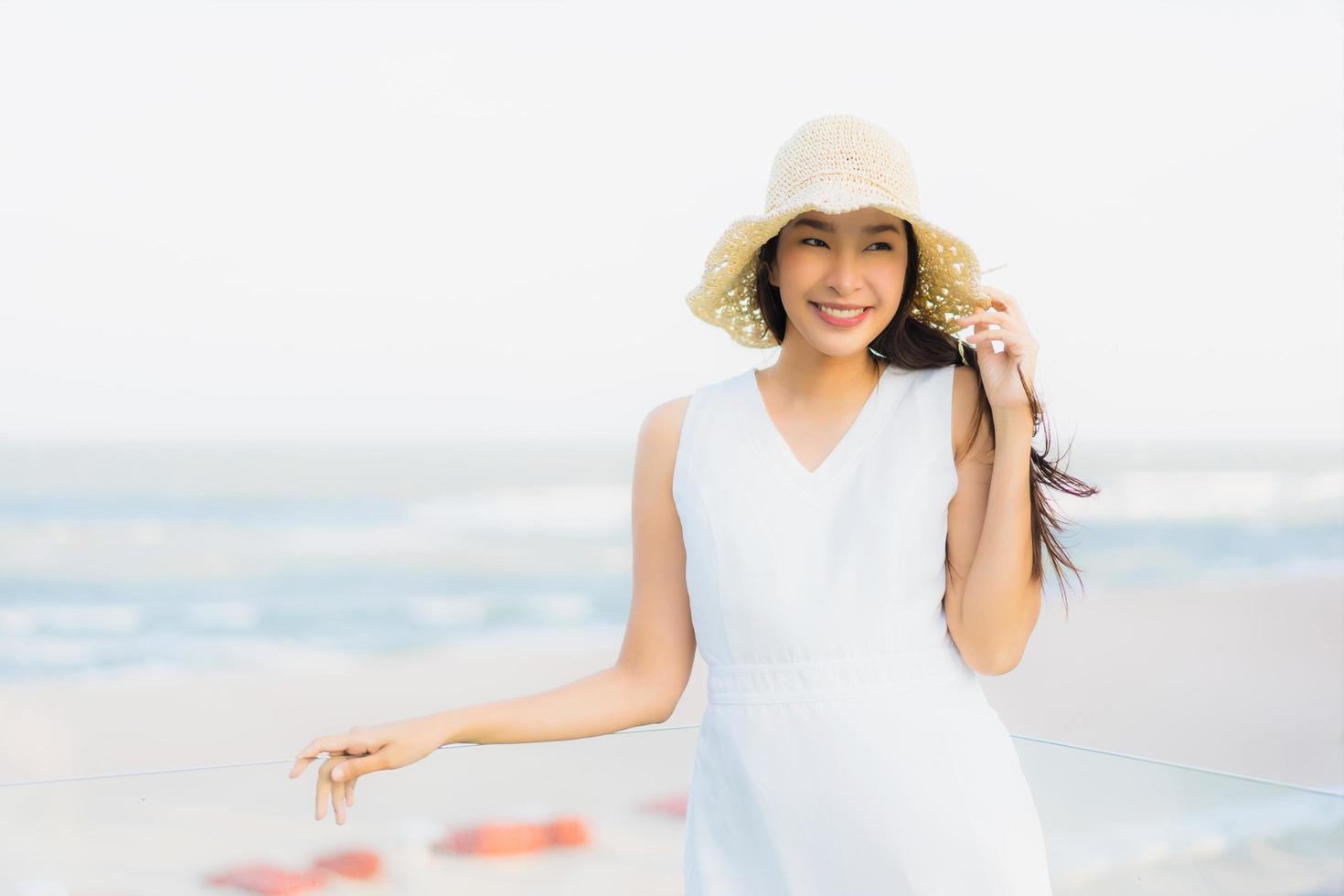 portret mooie jonge Aziatische vrouw gelukkig en glimlach op het strand zee en oceaan sea foto