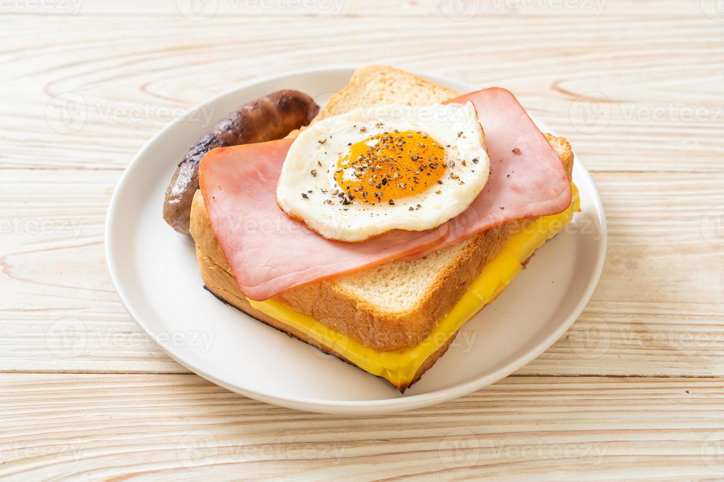 zelfgebakken brood geroosterde kaas belegde ham en gebakken ei met varkensworst als ontbijt foto