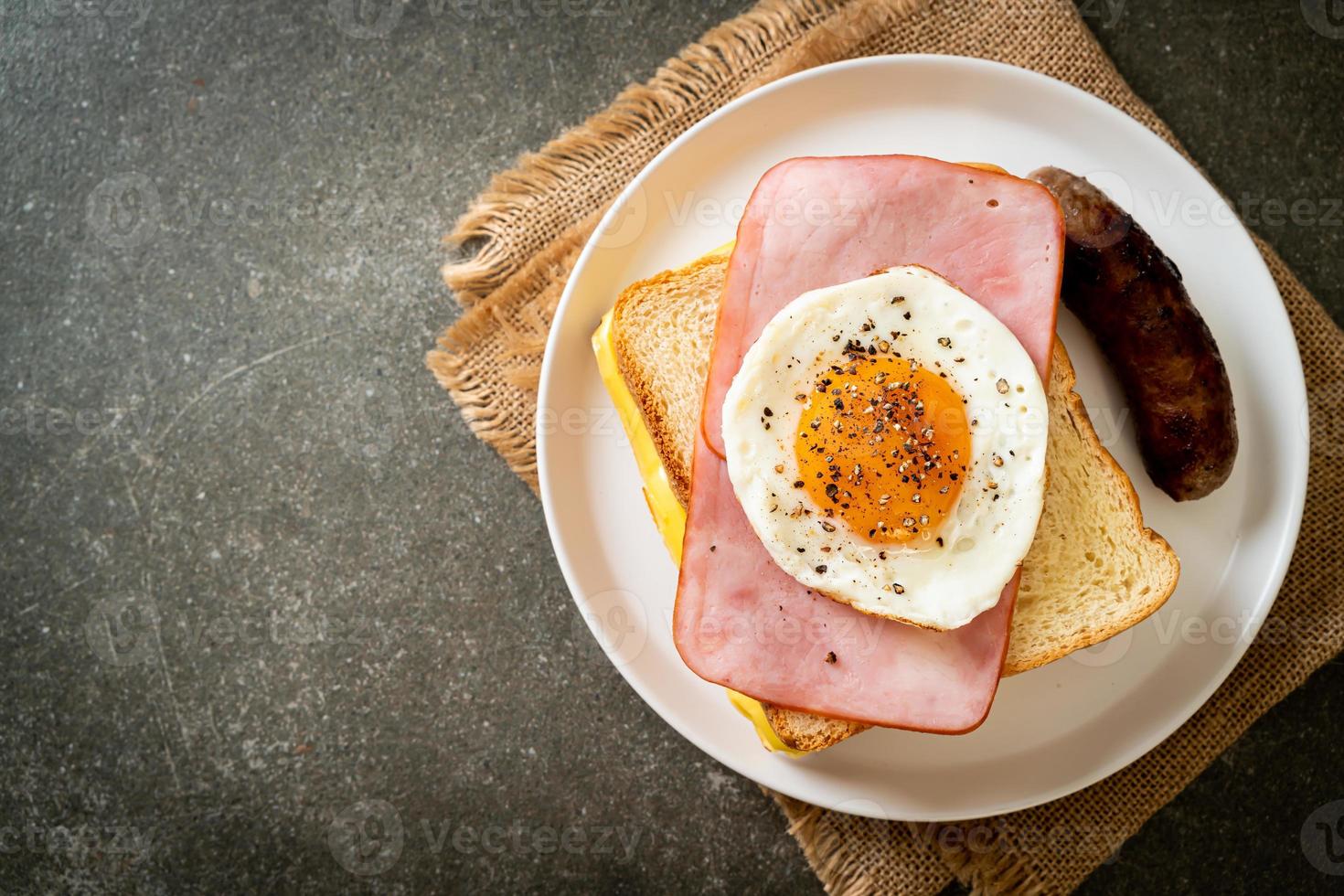 zelfgebakken brood geroosterde kaas belegde ham en gebakken ei met varkensworst als ontbijt foto