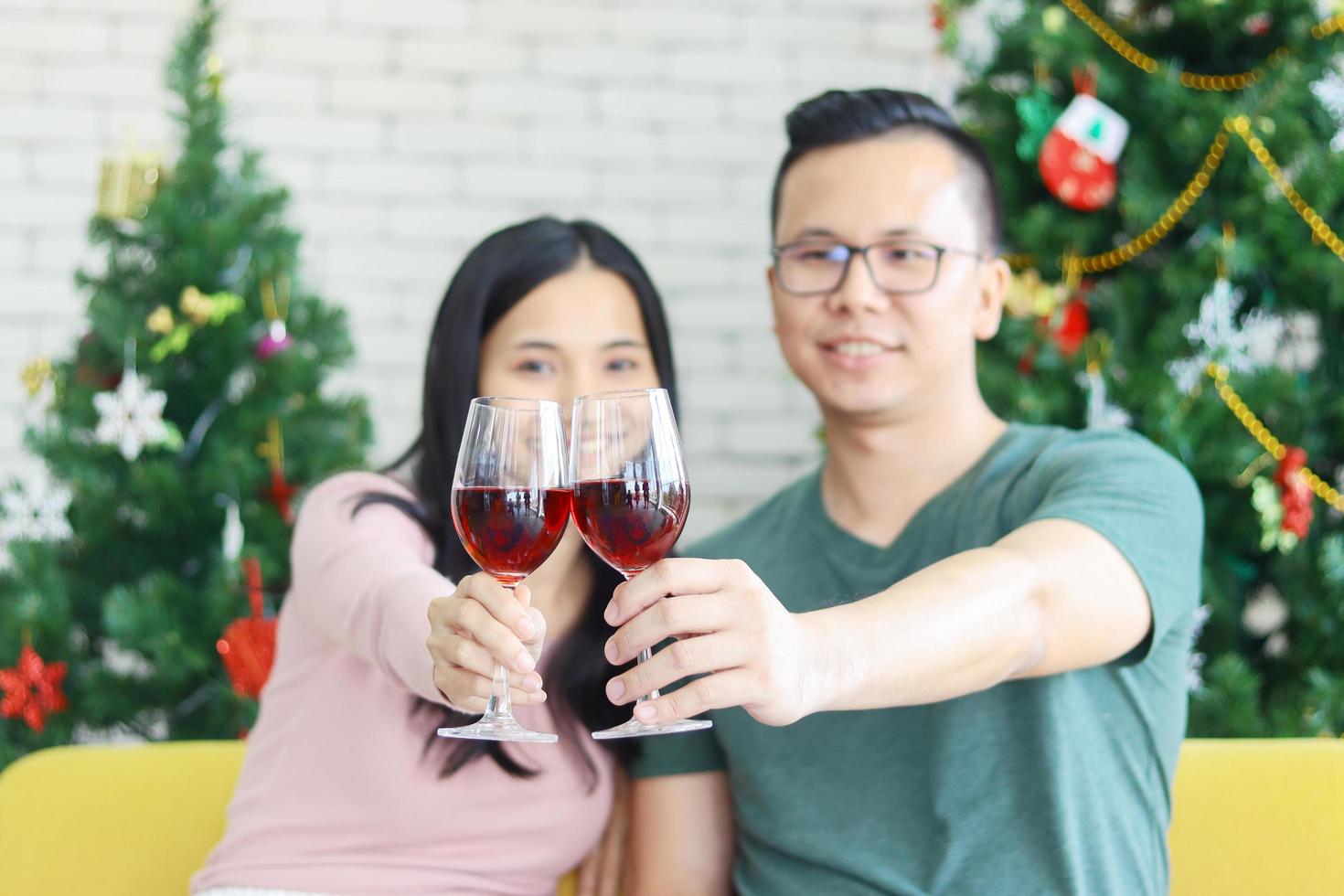 jong Aziatisch paar dat van Kerstmis met champagne geniet enjoying foto