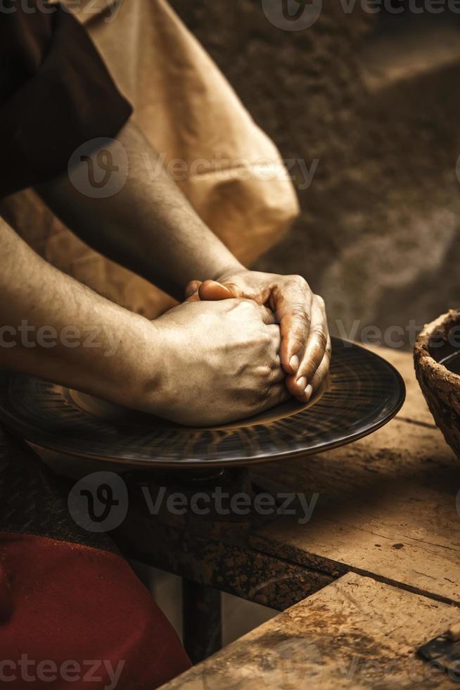 handen van een pottenbakker die klei vormt foto