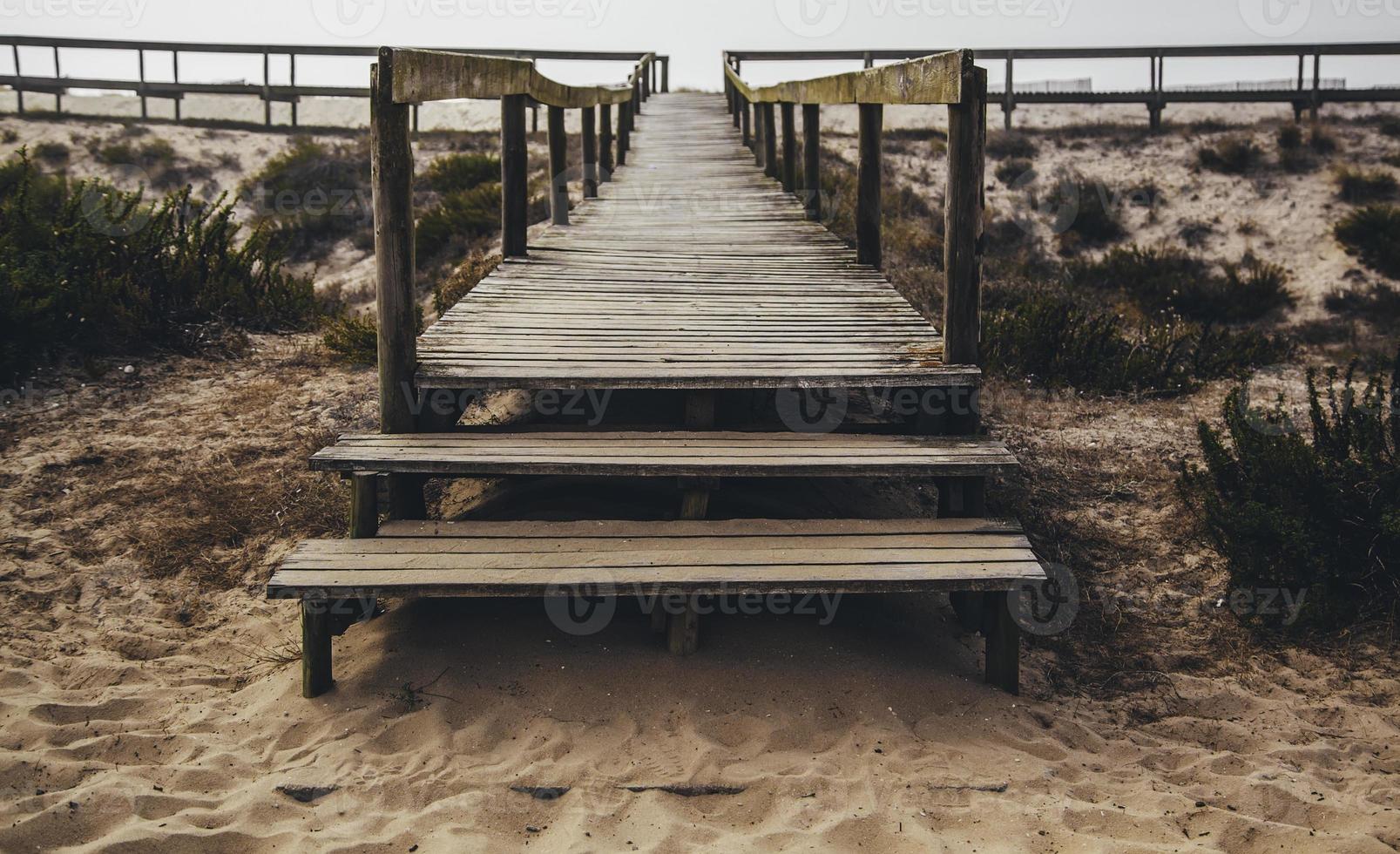 houten loopbrug op het strand foto