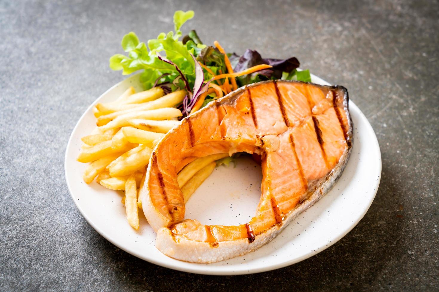 dubbel gegrilde zalm steakfilet met groente en frietjes foto