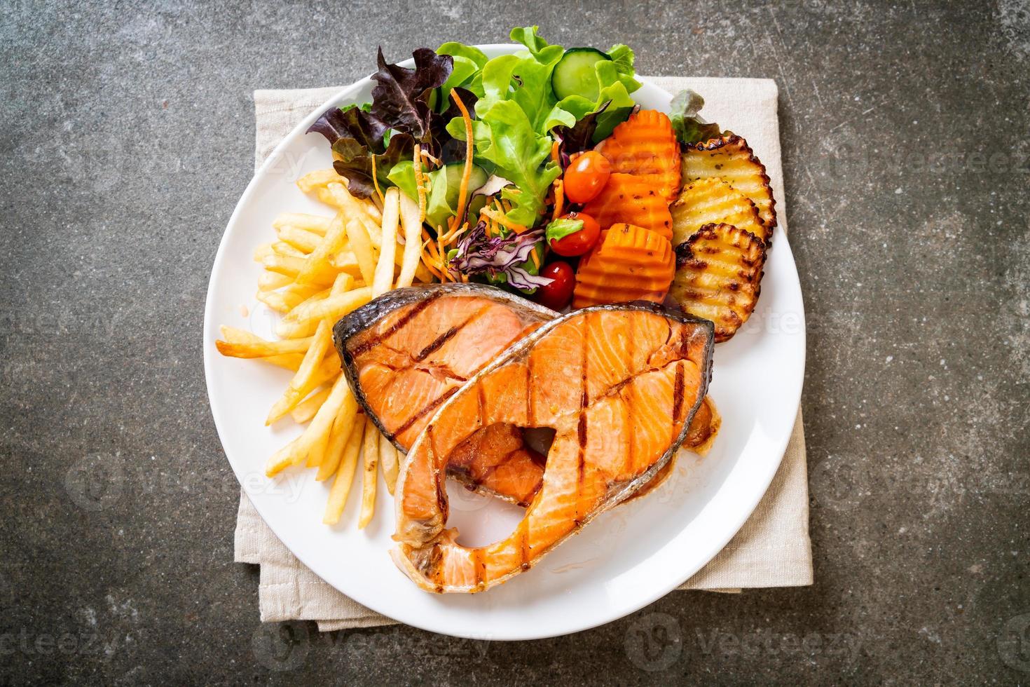 dubbel gegrilde zalm steakfilet met groente en frietjes foto