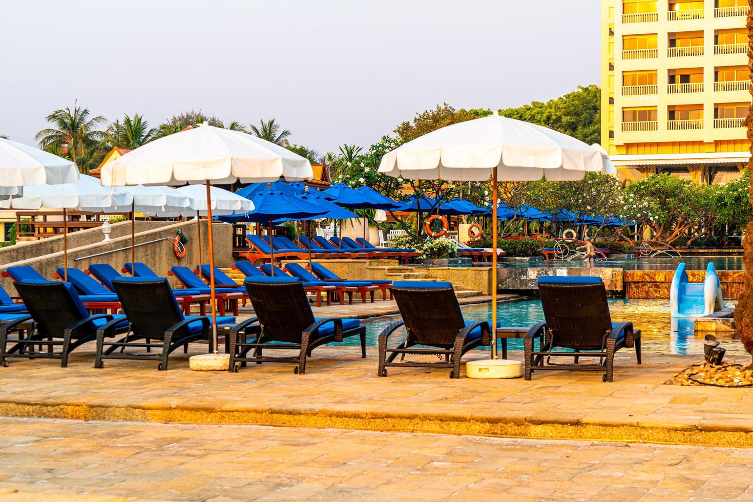 parasol strandstoel met palmboom en zee strand bij zonsopgang - vakantie en vakantie concept foto