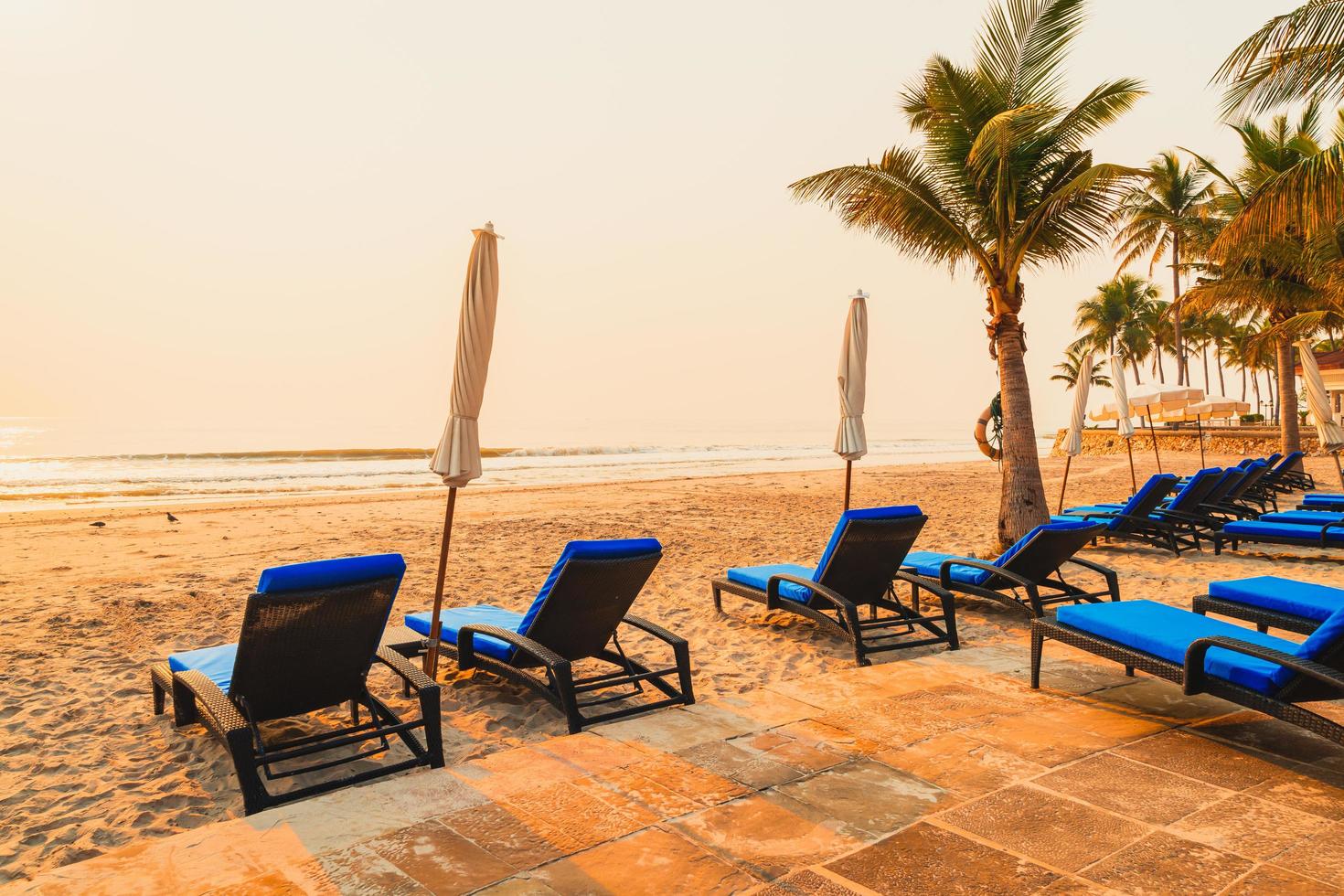 parasol strandstoel met palmboom en zee strand bij zonsopgang - vakantie en vakantie concept foto