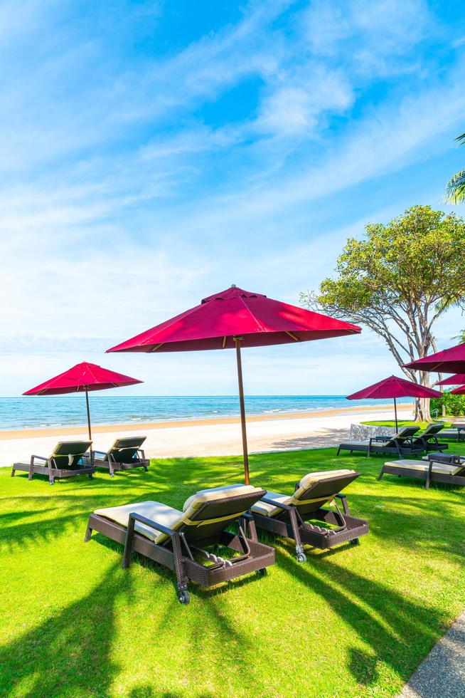 strandstoelen en parasols met oceaan zee strand achtergrond foto
