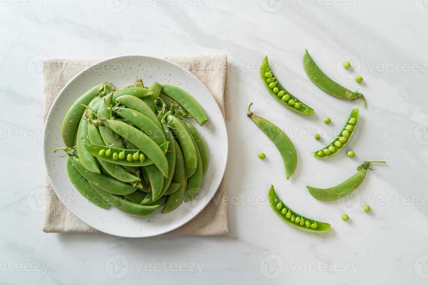 verse zoete groene erwten op witte plaat foto