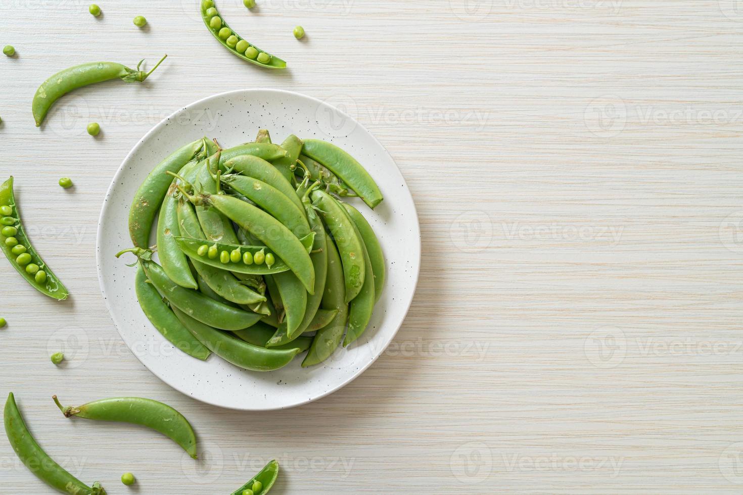 verse zoete groene erwten op witte plaat foto