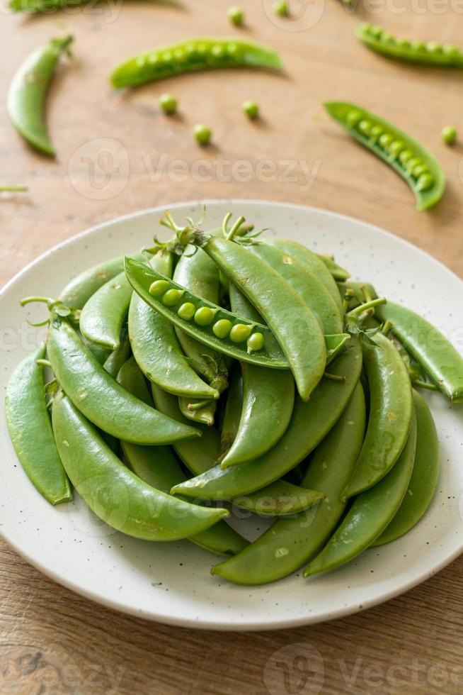 verse zoete groene erwten op witte plaat foto