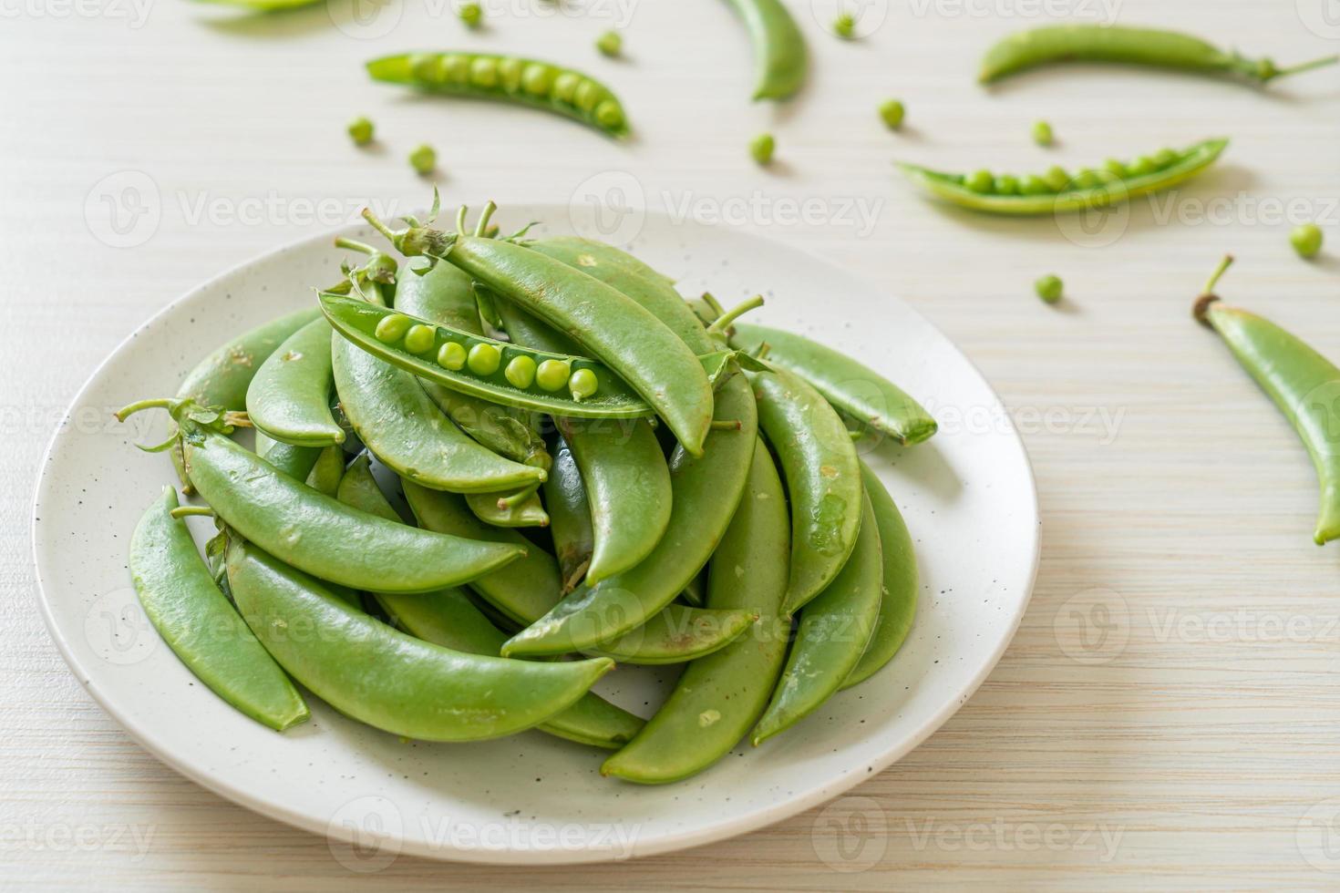 verse zoete groene erwten op witte plaat foto