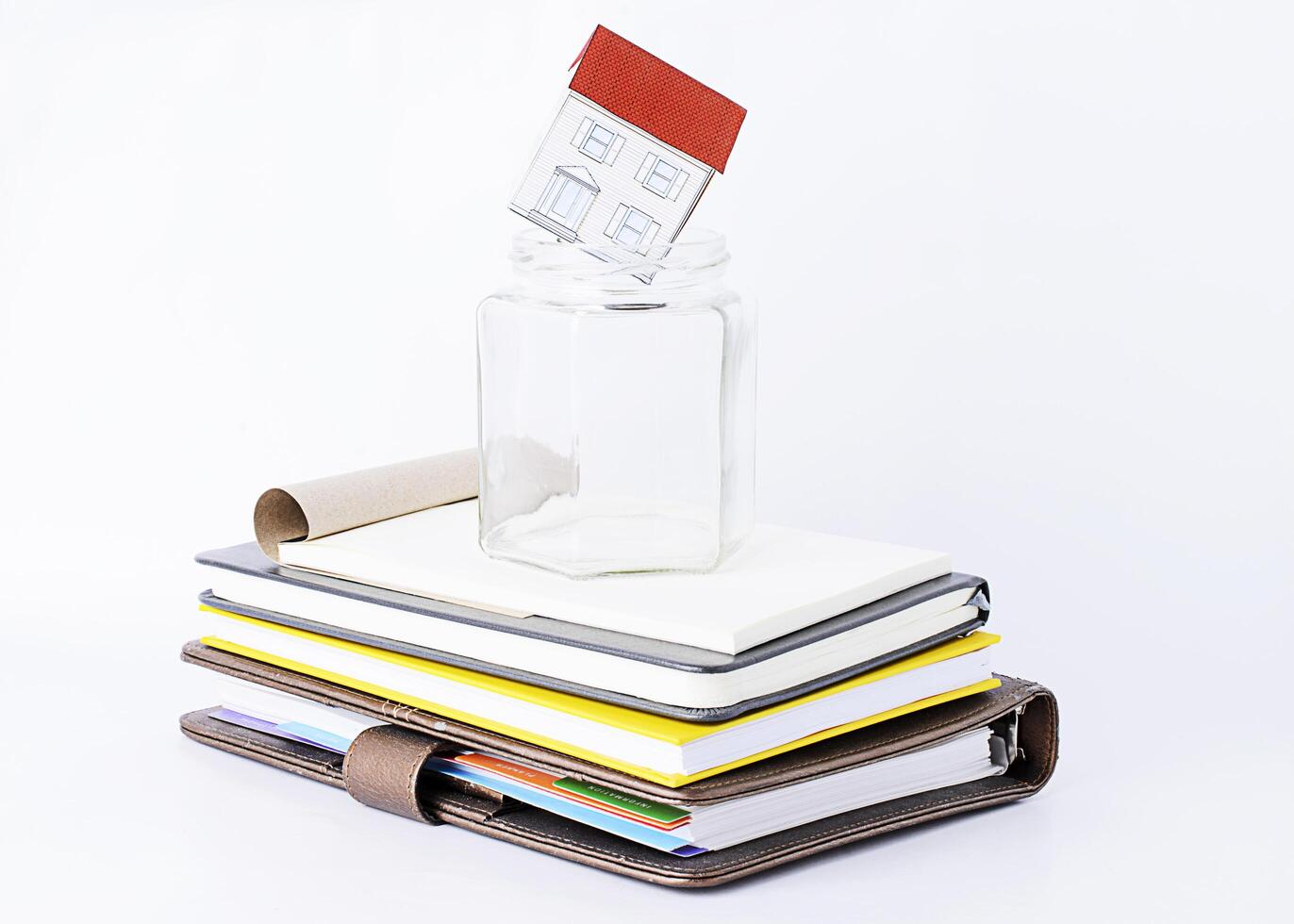 papier naar huis in leeg glas op stapel boeken foto