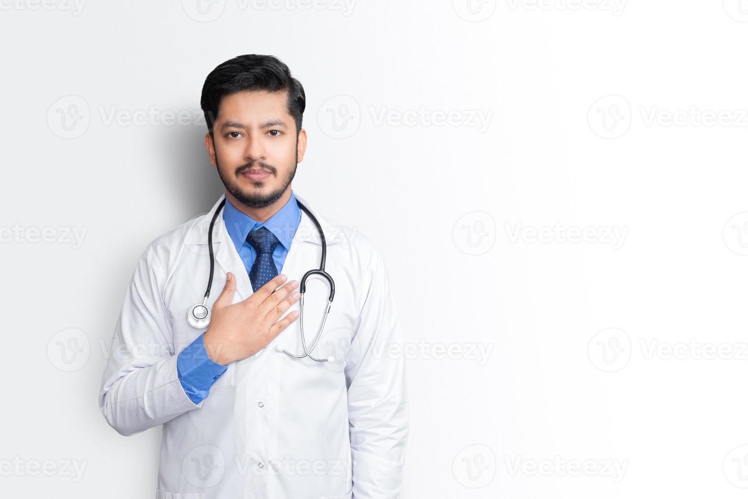 portret van mannelijke arts met stethoscoop en arm op borst geïsoleerd op een witte achtergrond. zorgverzekeringsconcept. foto
