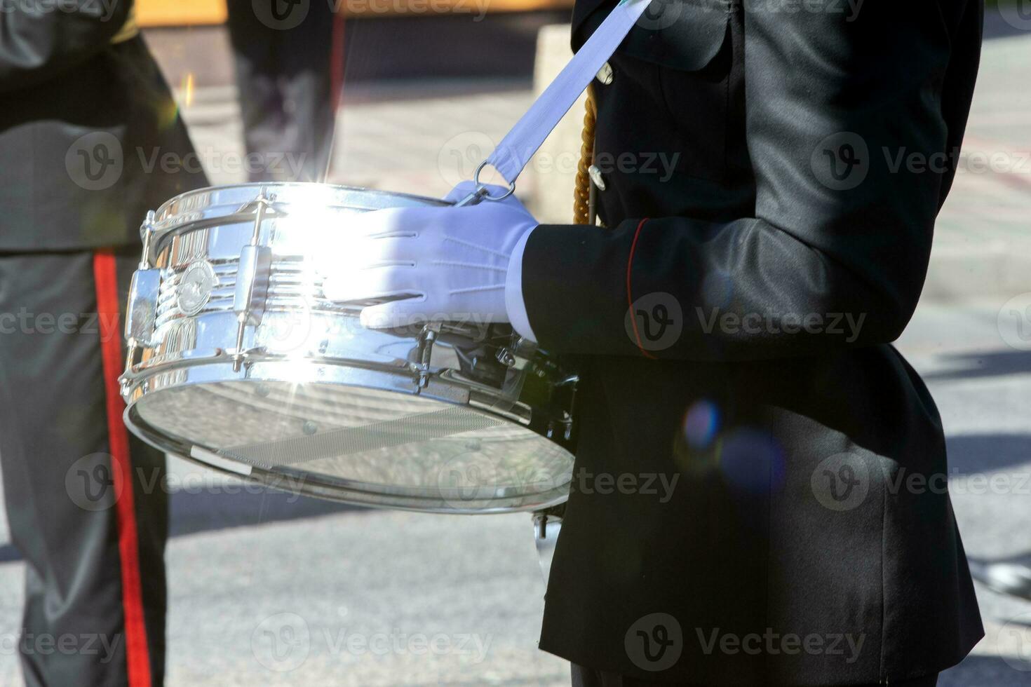 de zilver trommel in de handen van een leger band musicus sparkles in de zon. foto