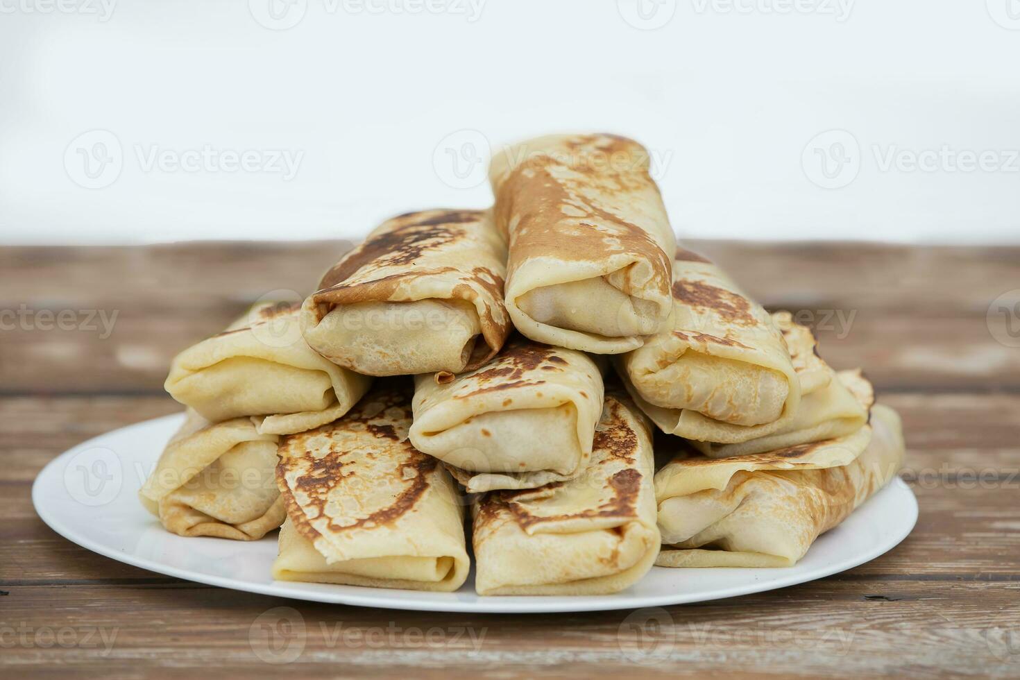 pannekoeken gerold in een buis Aan een bord. pannekoeken met vulling voor maslenitsa. foto