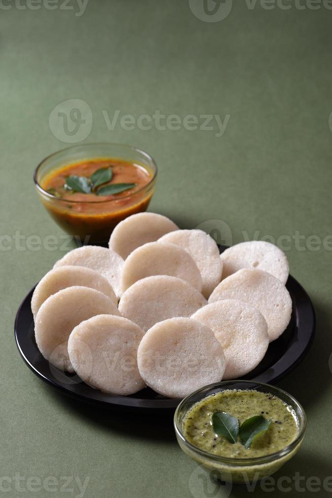 idli met sambar en kokoschutney, Indiaas gerecht Zuid-Indiaas favoriete eten rava idli of griesmeel werkeloos of rava nutteloos, geserveerd met sambar en groene chutney. foto